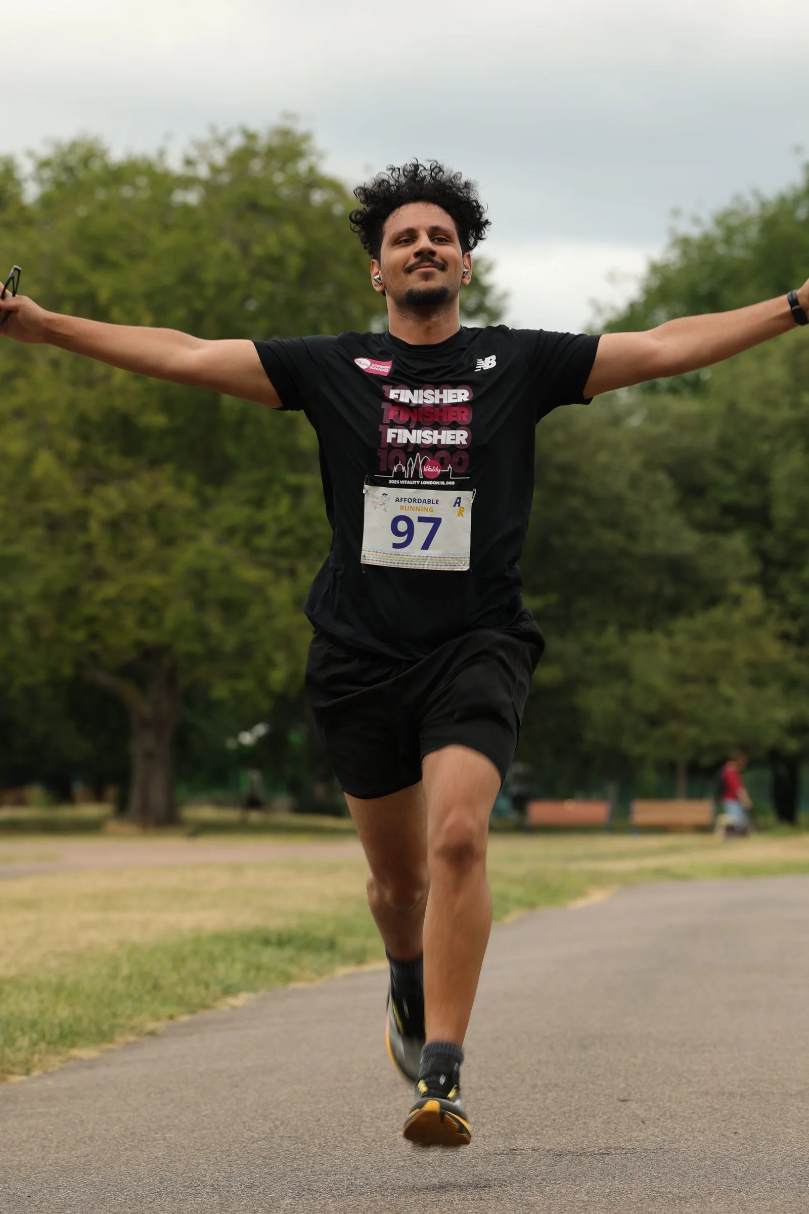 A runner celebrating at the finish of an Affordable Running 10K race in London