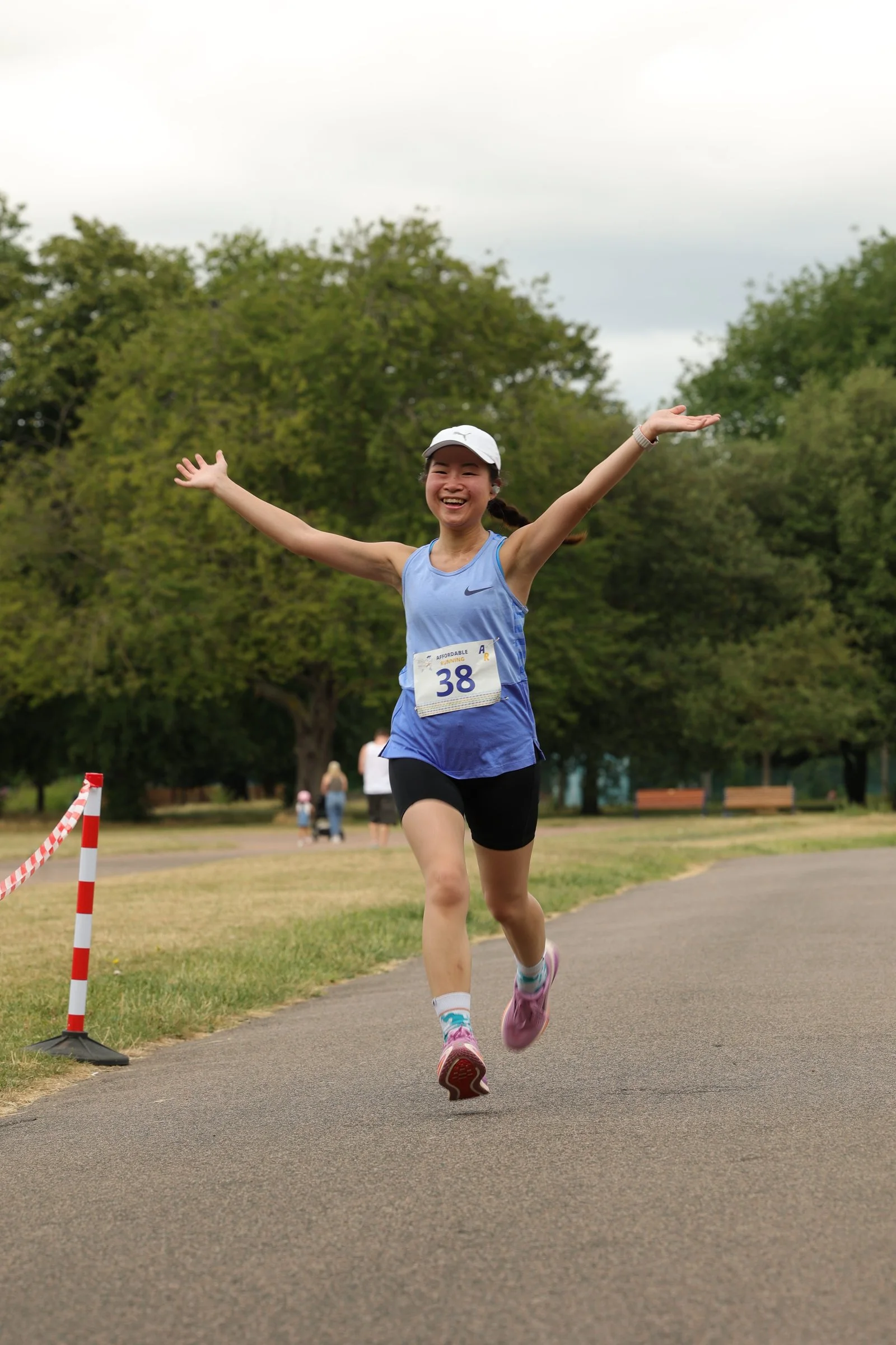 A runner celebrating at the finish of an Affordable Running 5K race in London